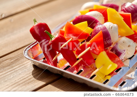 close up of vegetables on skewers on foil grill close up of vegetables on skewers on foil grill 66864873
