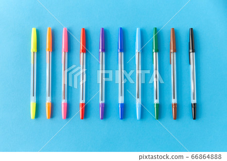 row of multicolored pens on blue background 66864888