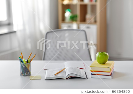 books, apple and school supplies on table at home books, apple and school supplies on table at home 66864890