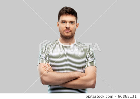 young man in striped t-shirt with crossed arms young man in striped t-shirt with crossed arms 66865131