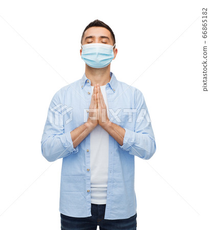 young man in protective medical mask praying young man in protective medical mask praying 66865182
