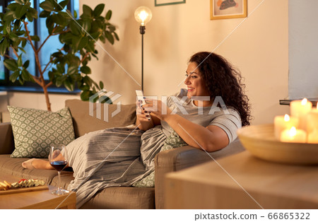 woman with smartphone at home in evening woman with smartphone at home in evening 66865322