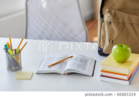 books, apple and school supplies on table at home books, apple and school supplies on table at home 66865329