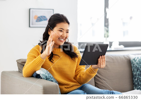 woman with tablet pc having video call at home woman with tablet pc having video call at home 66865330