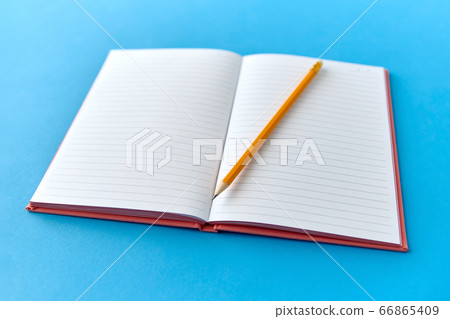 open notebook with pencil on blue background 66865409