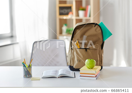books, apple and school supplies on table at home 66865411