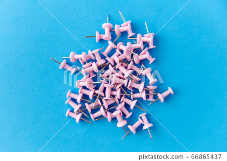 heap of pink office pins on blue background heap of pink office pins on blue background 66865437