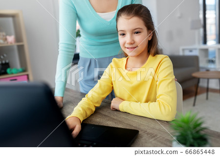 mother and daughter with laptop doing homework mother and daughter with laptop doing homework 66865448