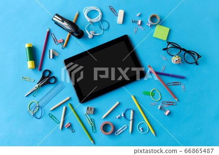 tablet pc and school supplies on blue background tablet pc and school supplies on blue background 66865487