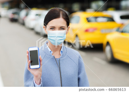 woman in face mask with smartphone in city woman in face mask with smartphone in city 66865613