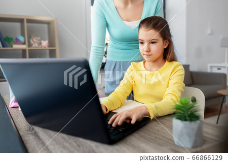 mother and daughter with laptop doing homework mother and daughter with laptop doing homework 66866129