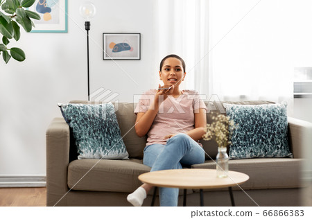woman recording voice with smartphone at home woman recording voice with smartphone at home 66866383