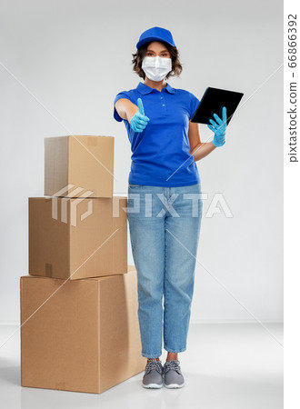 delivery woman in mask with boxes and tablet pc delivery woman in mask with boxes and tablet pc 66866392