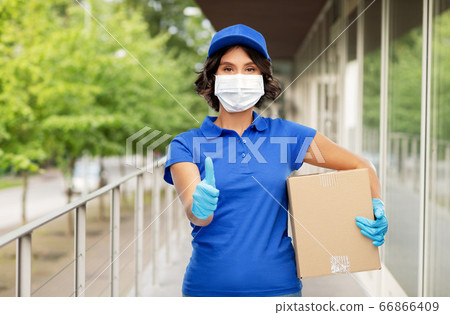 delivery woman in mask holding parcel box outdoors delivery woman in mask holding parcel box outdoors 66866409