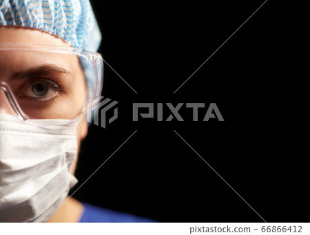 female doctor or nurse in goggles and face mask 66866412