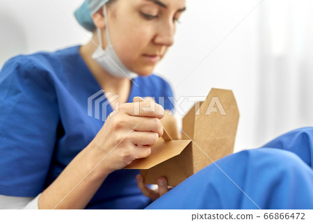 sad doctor or nurse eating takeaway food from box sad doctor or nurse eating takeaway food from box 66866472