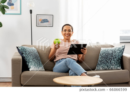 african woman with tablet pc and apple at home african woman with tablet pc and apple at home 66866599