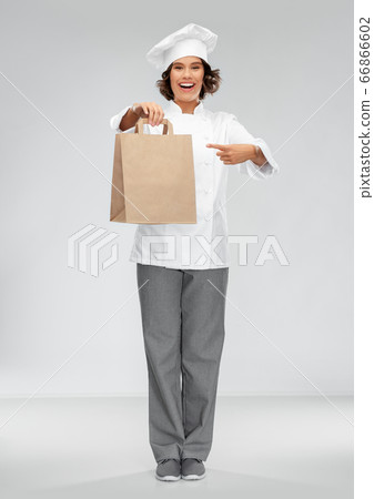 happy female chef with takeaway food in paper bag happy female chef with takeaway food in paper bag 66866602