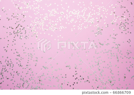Confetti of gold stars glisten on a pink background. Festive holiday pastel backdrop. Confetti of gold stars glisten on a pink background. Festive holiday pastel backdrop. 66866709