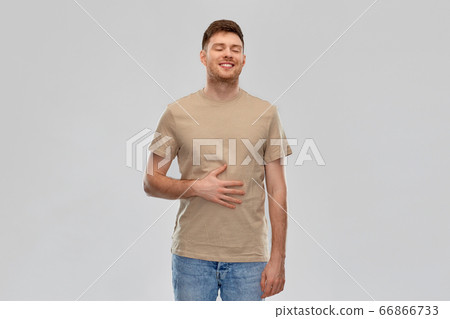 happy full man touching tummy over gray background 66866733