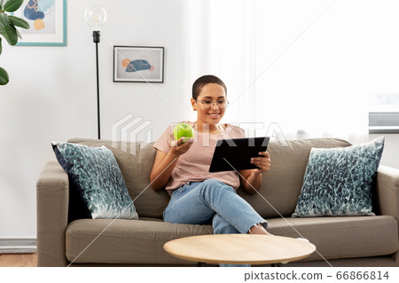 african woman with tablet pc and apple at home african woman with tablet pc and apple at home 66866814