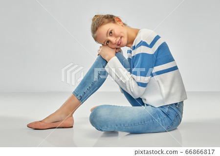 smiling teenage girl in pullover sitting on floor smiling teenage girl in pullover sitting on floor 66866817