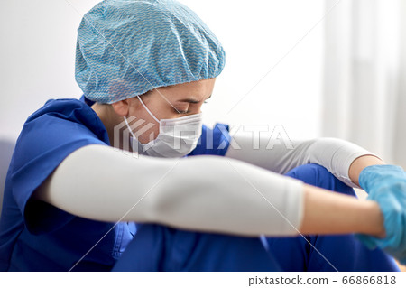 sad doctor or nurse in protective face mask 66866818