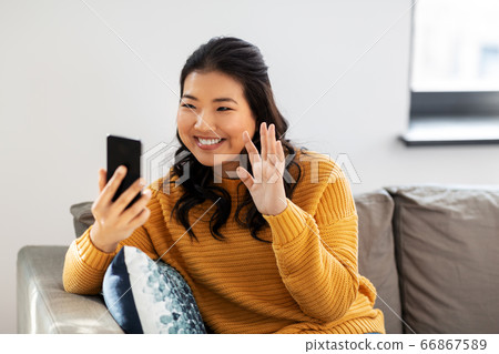 woman with smartphone having video call at home woman with smartphone having video call at home 66867589