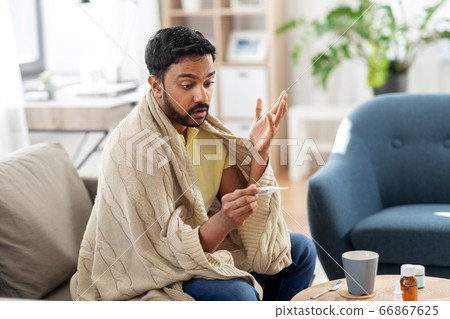 sick man measuring temperature by thermometer 66867625