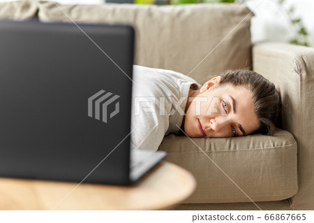 bored woman with laptop lying on sofa at home bored woman with laptop lying on sofa at home 66867665