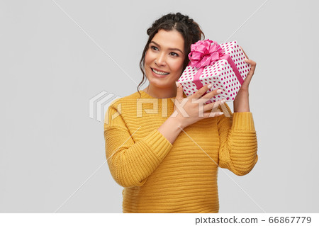 smiling young woman holding gift box 66867779