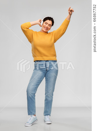 happy woman in headphones listening to music happy woman in headphones listening to music 66867782