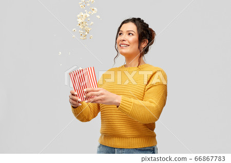 happy smiling young woman playing with popcorn 66867783