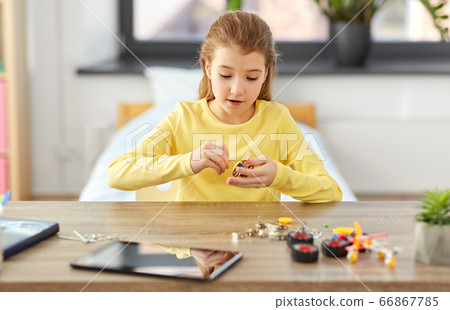 happy girl playing with robotics kit at home happy girl playing with robotics kit at home 66867785
