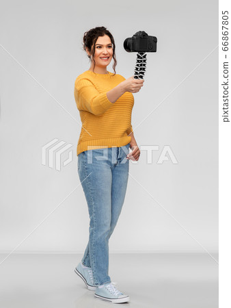 smiling woman blogger with camera recording video smiling woman blogger with camera recording video 66867805