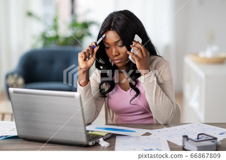 woman with laptop calling on phone at home office woman with laptop calling on phone at home office 66867809