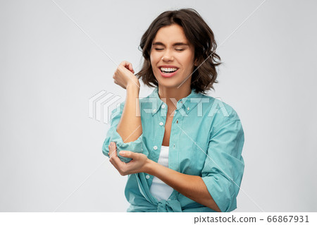 young woman in shirt suffering from pain in hand young woman in shirt suffering from pain in hand 66867931
