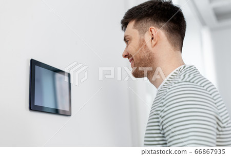 happy man looking at tablet computer at smart home happy man looking at tablet computer at smart home 66867935