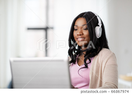 woman in headphones with laptop working at home woman in headphones with laptop working at home 66867974