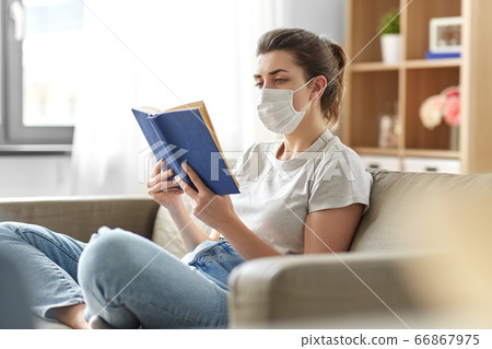 sick woman in medical mask reading book at home 66867975
