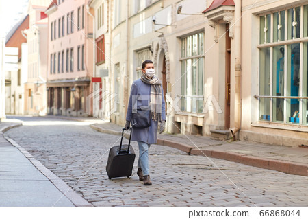 woman in protective mask with travel bag in city woman in protective mask with travel bag in city 66868044