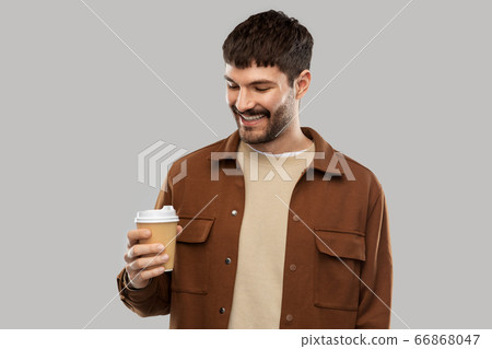 smiling young man with takeaway coffee cup smiling young man with takeaway coffee cup 66868047
