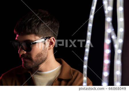 man in sunglasses over neon lights at nightclub man in sunglasses over neon lights at nightclub 66868049