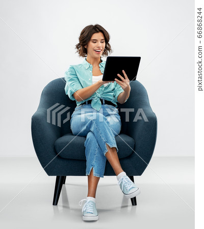 happy woman with tablet pc sitting in armchair happy woman with tablet pc sitting in armchair 66868244