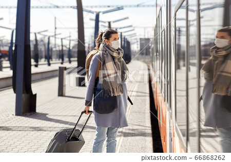 woman in protective face mask at railway station 66868262