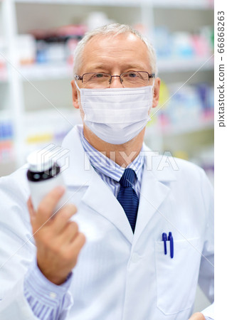 old apothecary in mask with medicine at pharmacy old apothecary in mask with medicine at pharmacy 66868263