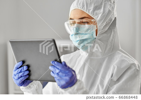 doctor in protective wear with tablet computer doctor in protective wear with tablet computer 66868448