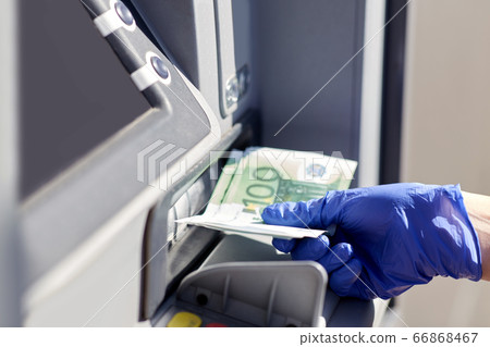 hand in medical glove with money at atm machine hand in medical glove with money at atm machine 66868467