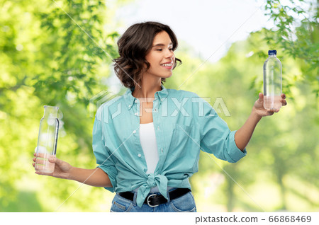 smiling young woman comparing bottles of water smiling young woman comparing bottles of water 66868469