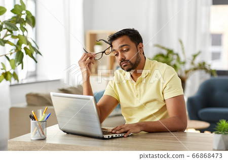 bored man with laptop working at home office 66868473